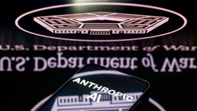 Anthropic AI logo on phone screen with Department of Defense logo in background.