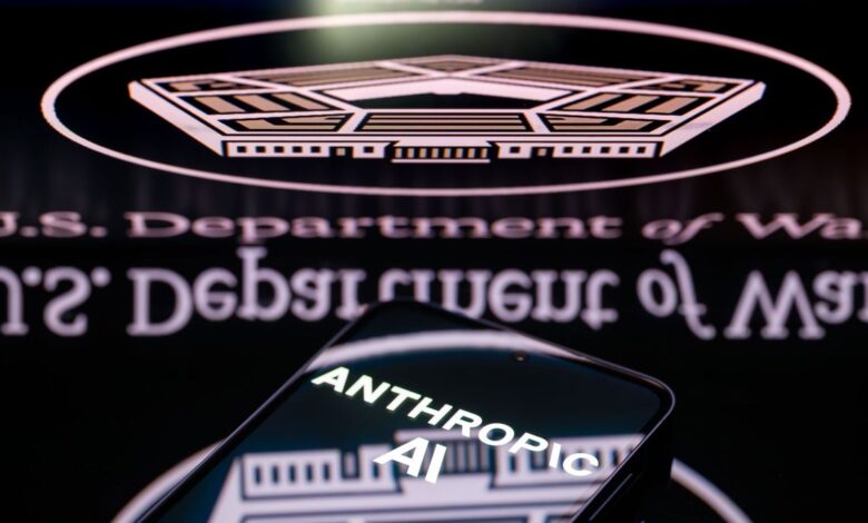 Anthropic AI logo on phone screen with Department of Defense logo in background.