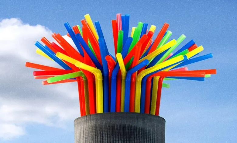 Colorful straws in a gray container against a blue sky backdrop.