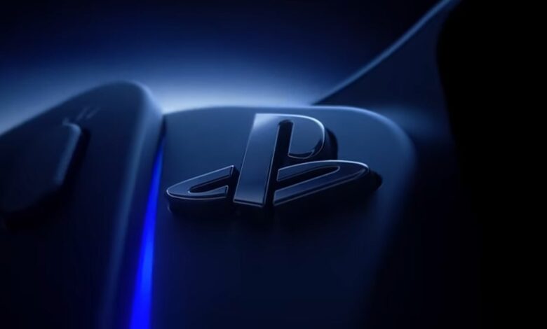 Close-up of a PlayStation logo on a dark blue surface with a blue light.