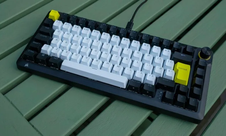 Custom mechanical keyboard with black and white keycaps and yellow accents.
