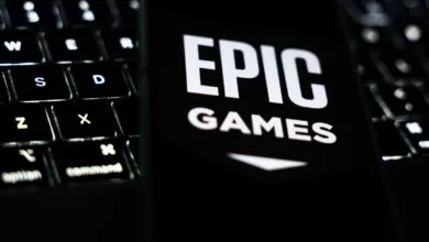 Epic Games logo displayed on a phone screen next to a laptop keyboard.