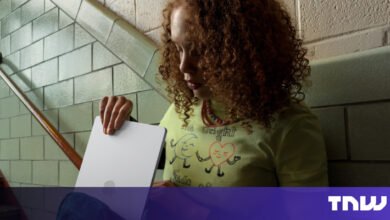 Person holding a tablet on a staircase with tiled walls.