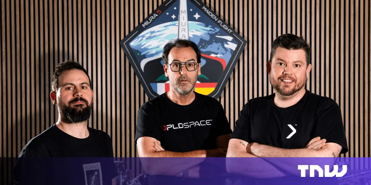 Three men stand in front of a PLD Space logo, smiling at the camera.