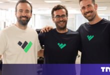 Three men smiling, wearing shirts with a company logo.