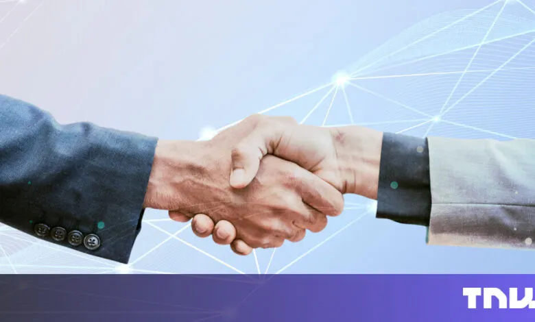 Two people in suits shaking hands against a light blue, networked background.