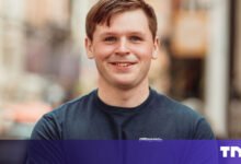 Portrait of a smiling man with short brown hair wearing a Patagonia t-shirt.