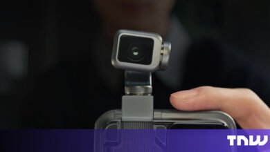 Compact camera attached to a smartphone, close-up view.