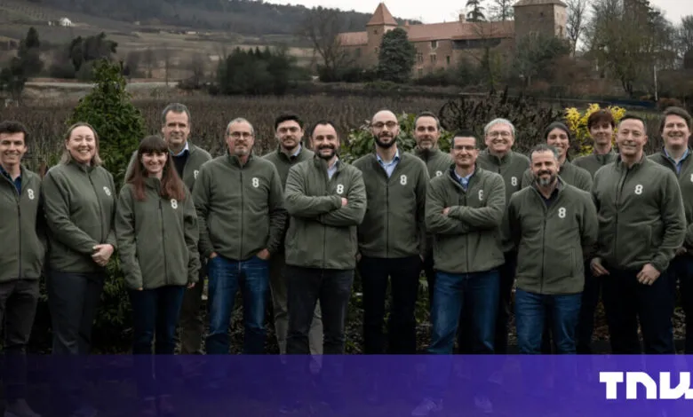 Group of people in matching jackets stand outdoors.