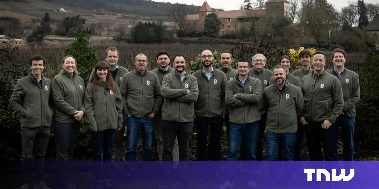 Group of people in matching jackets stand outdoors.