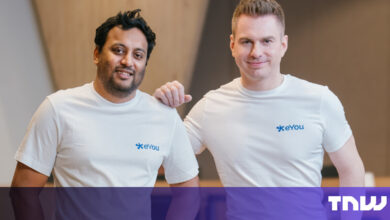 Two men in white shirts with the eYou logo stand smiling.