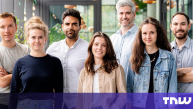 Group of seven diverse professionals smiling indoors.