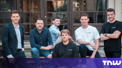 Group of six men posing outdoors on steps, smiling at the camera.
