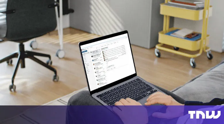 Laptop displaying email interface on person's lap in a home office setting.