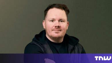 Headshot of a man with short brown hair and a black vest.