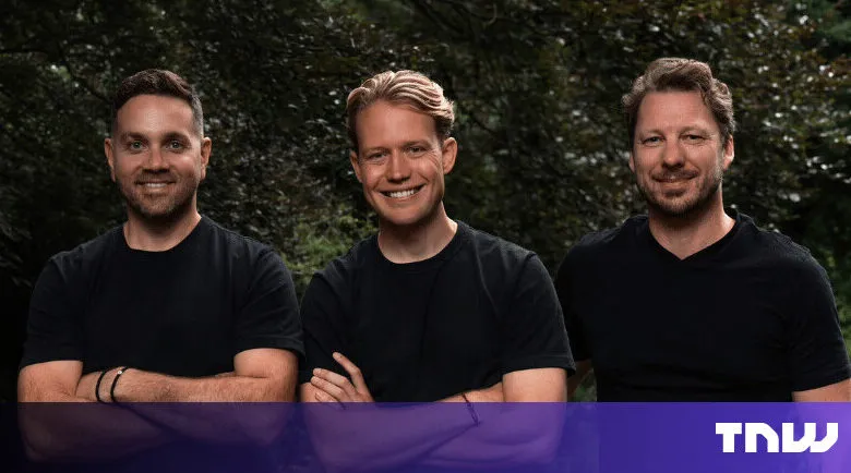 Three men stand smiling with arms crossed against a leafy backdrop.