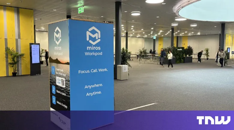 Miros Workpod advertisement in a convention hall with people walking around.