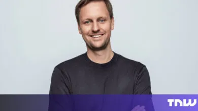 Portrait of smiling man with short hair and dark shirt.