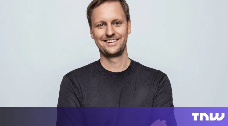 Portrait of smiling man with short hair and dark shirt.