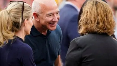 Jeff Bezos in conversation with two women at an outdoor event.