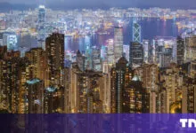 Hong Kong skyline at night with illuminated buildings.