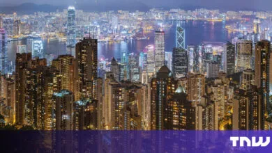 Hong Kong skyline at night with illuminated buildings.