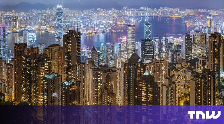 Hong Kong skyline at night with illuminated buildings.
