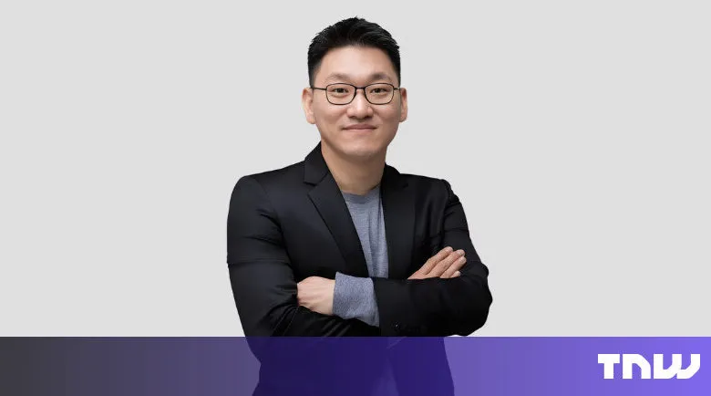 Portrait of a man with glasses and arms crossed, smiling slightly.