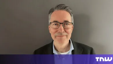 Portrait of a man with glasses against a gray background.