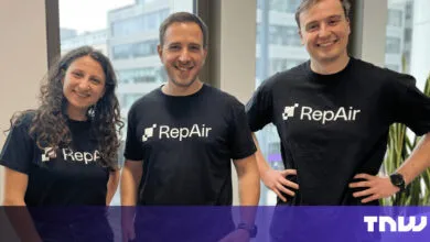 Three smiling people wearing RepAir t-shirts stand indoors.