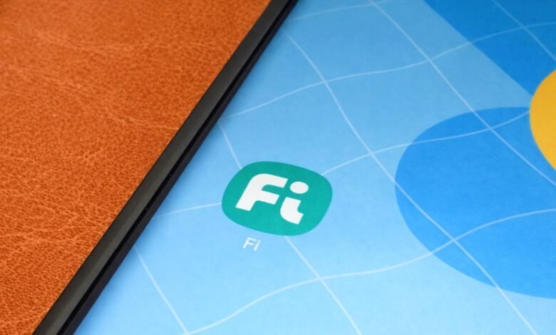 Fi money app icon on a phone screen with a colorful background.