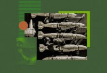 Bombs lined up on a carrier deck, with personnel working on them.