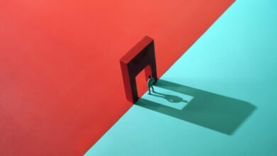 Miniature figure stands in doorway between red and blue backgrounds.