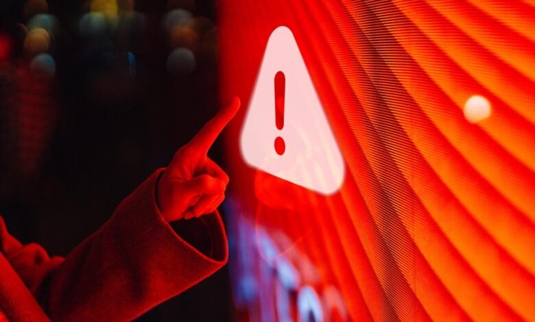 Hand points to warning sign on bright red digital display.