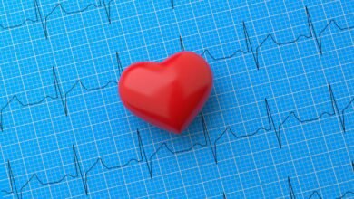 Red heart shape on blue ECG graph background.