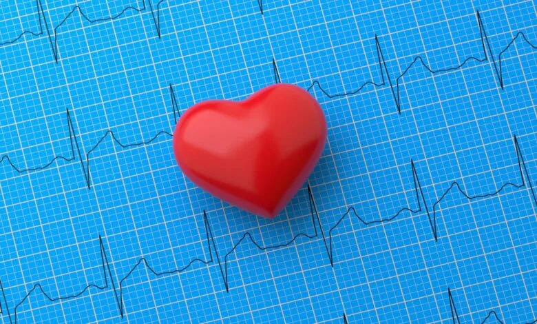 Red heart shape on blue ECG graph background.