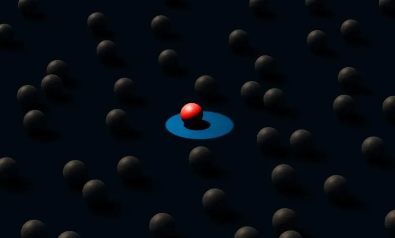 Red sphere stands out among gray spheres, highlighted by blue light.