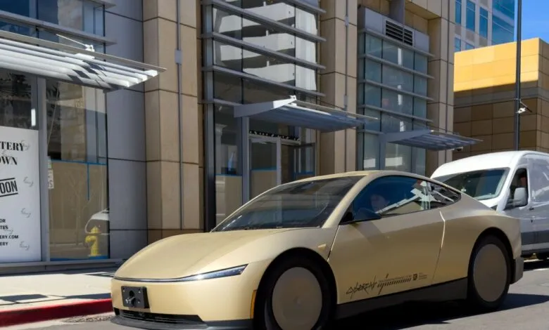 Lucid Gravity SUV prototype in gold color parked on city street.