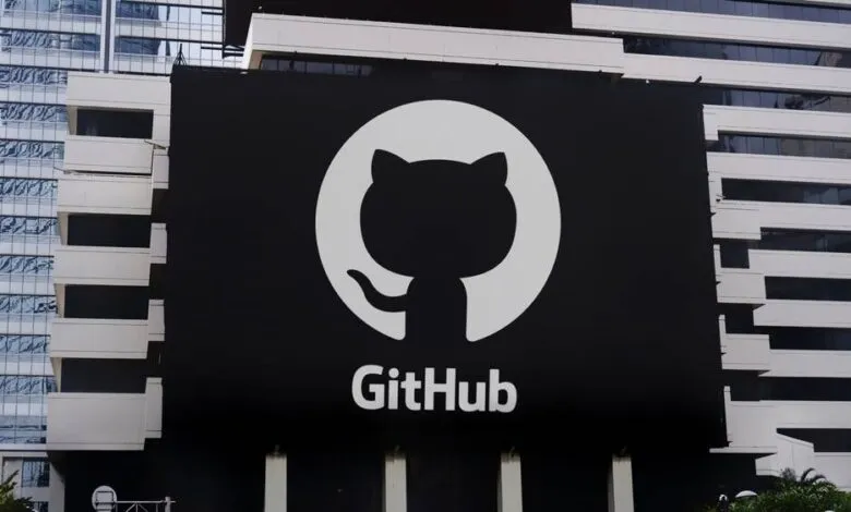 Large GitHub logo on building, white Octocat on black background.