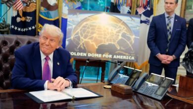 Donald Trump sits at desk with 'Golden Dome for America' poster.