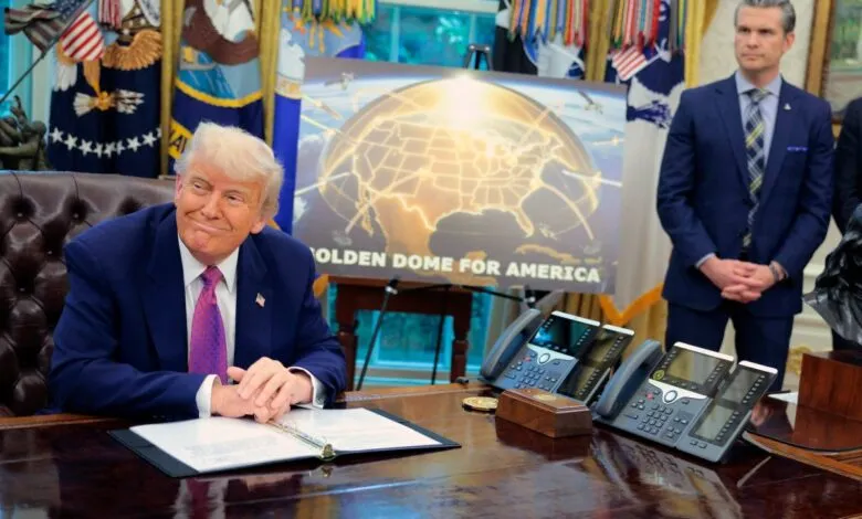 Donald Trump sits at desk with 'Golden Dome for America' poster.