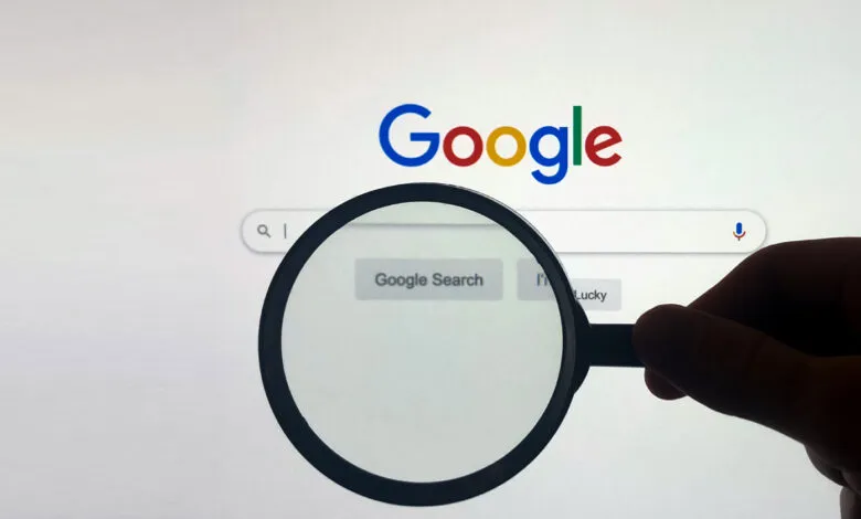Magnifying glass over Google search bar on a screen.