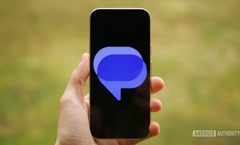 Hand holding smartphone displaying the Google Messages logo.