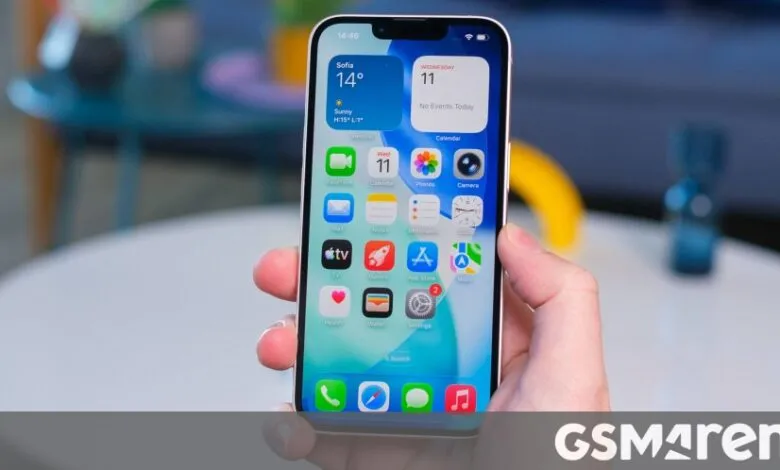 Close-up of iPhone screen displaying iOS home screen with various app icons.