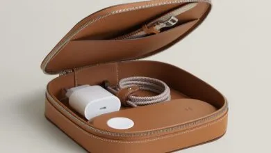 Open brown leather case with charger, watch band, and charging puck.