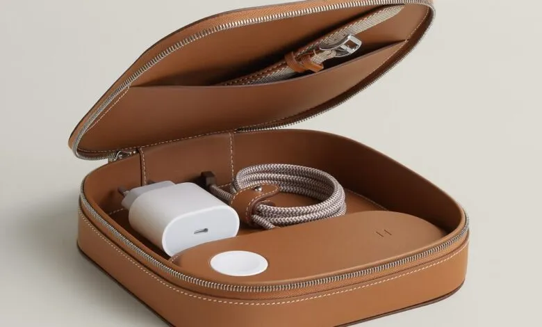 Open brown leather case with charger, watch band, and charging puck.