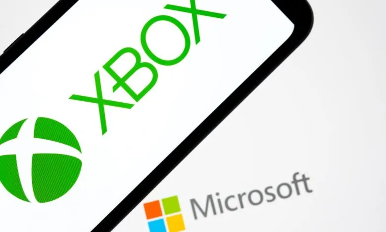 Close-up of a phone displaying the Xbox and Microsoft logos.