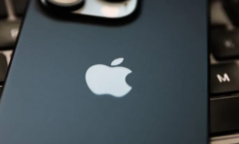 Close-up of an iPhone with the Apple logo on a keyboard.
