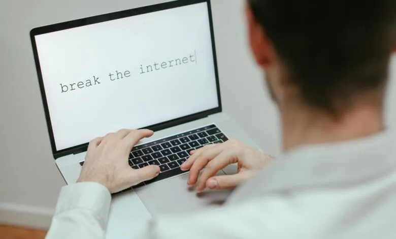 Person types 'break the internet' on laptop screen.