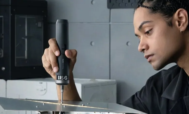 Person using HOTO precision screwdriver on metal object.